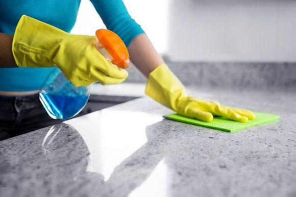 Küchenplatte wird mit Reinigungsmittel geputzt